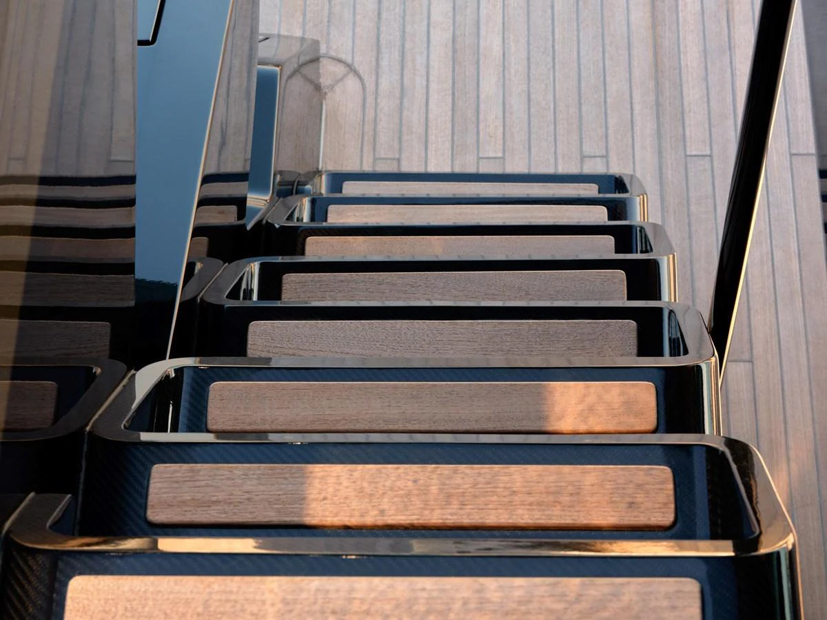 The image showcases a sleek and modern staircase with wooden steps and black railings. aboard 50 SHADES OF PLAY Yacht for Sale