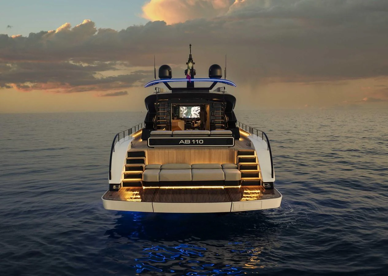 The yacht's aft deck is beautifully illuminated against a serene sunset backdrop. aboard 50 SHADES OF PLAY Yacht for Sale