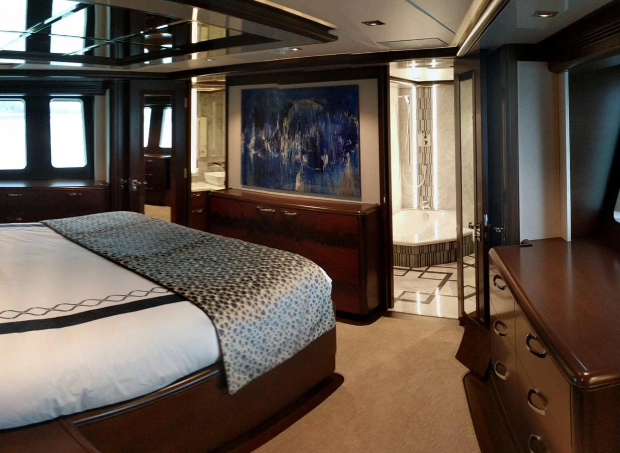 a bedroom with a bed and a desk aboard VIVIERAE II Yacht for Sale