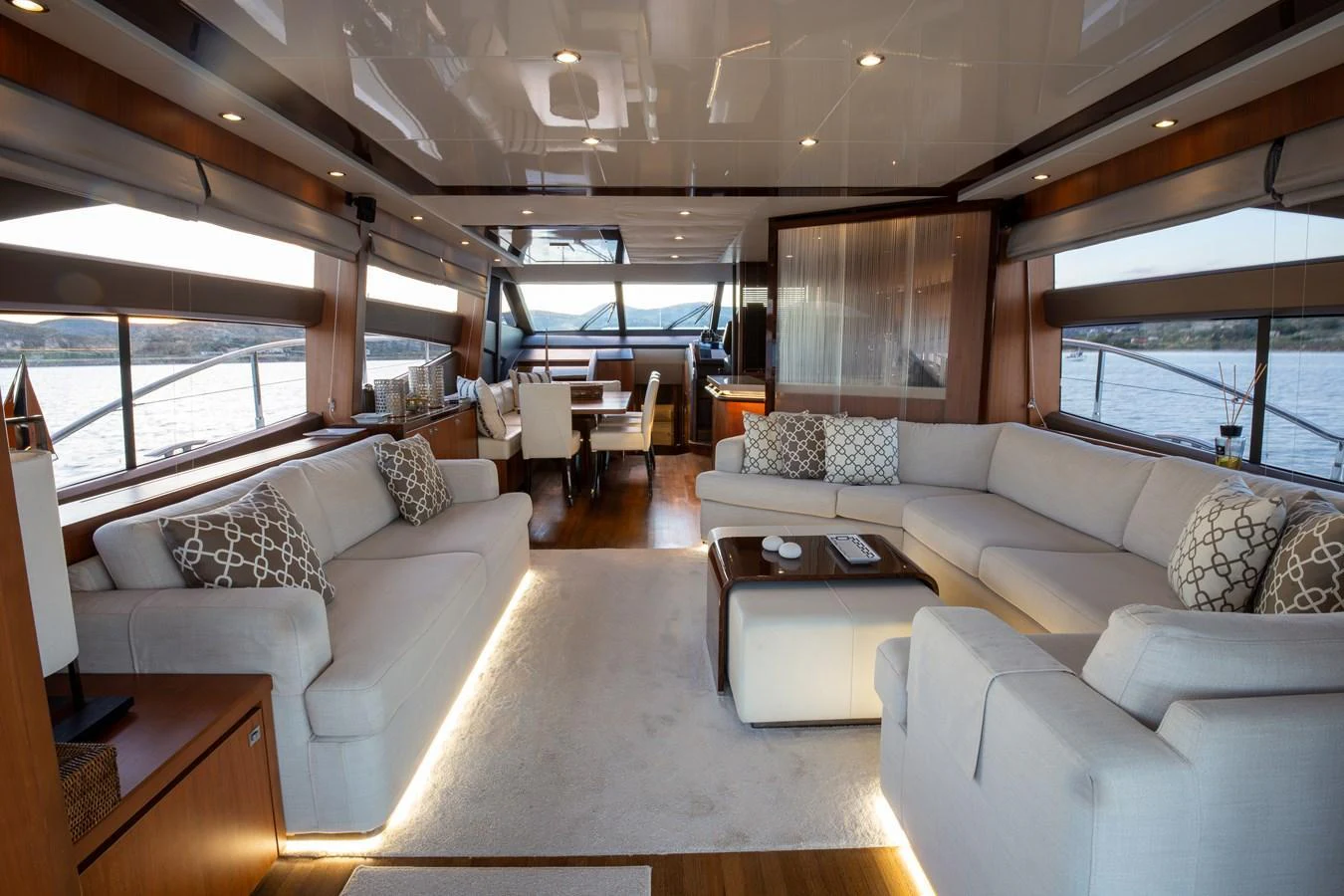 The spacious salon features elegant seating with panoramic views through large windows. aboard LAVIMAR II Yacht for Sale