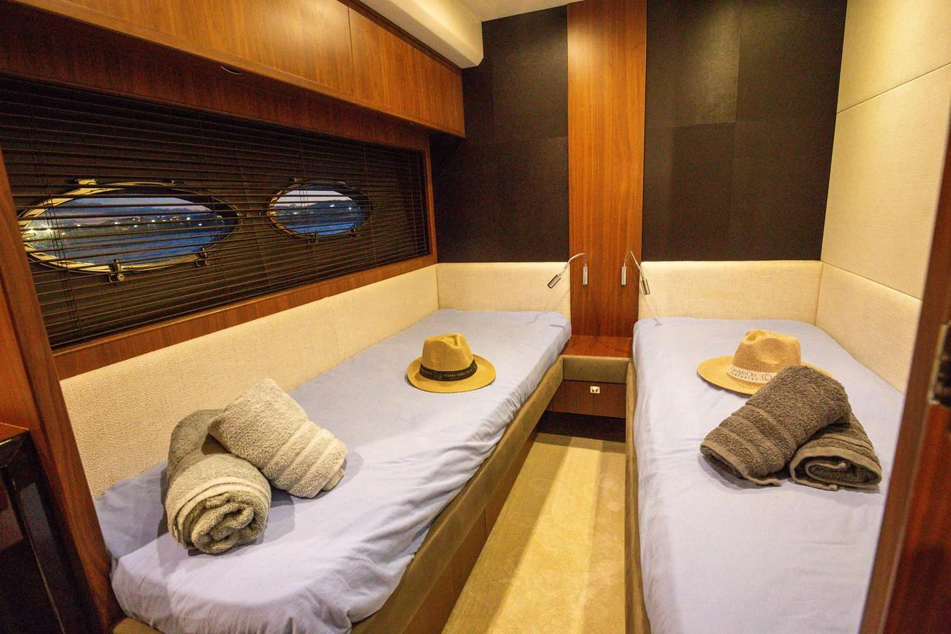 The twin stateroom features two single beds with cozy linens and stylish decor. aboard LAVIMAR II Yacht for Sale