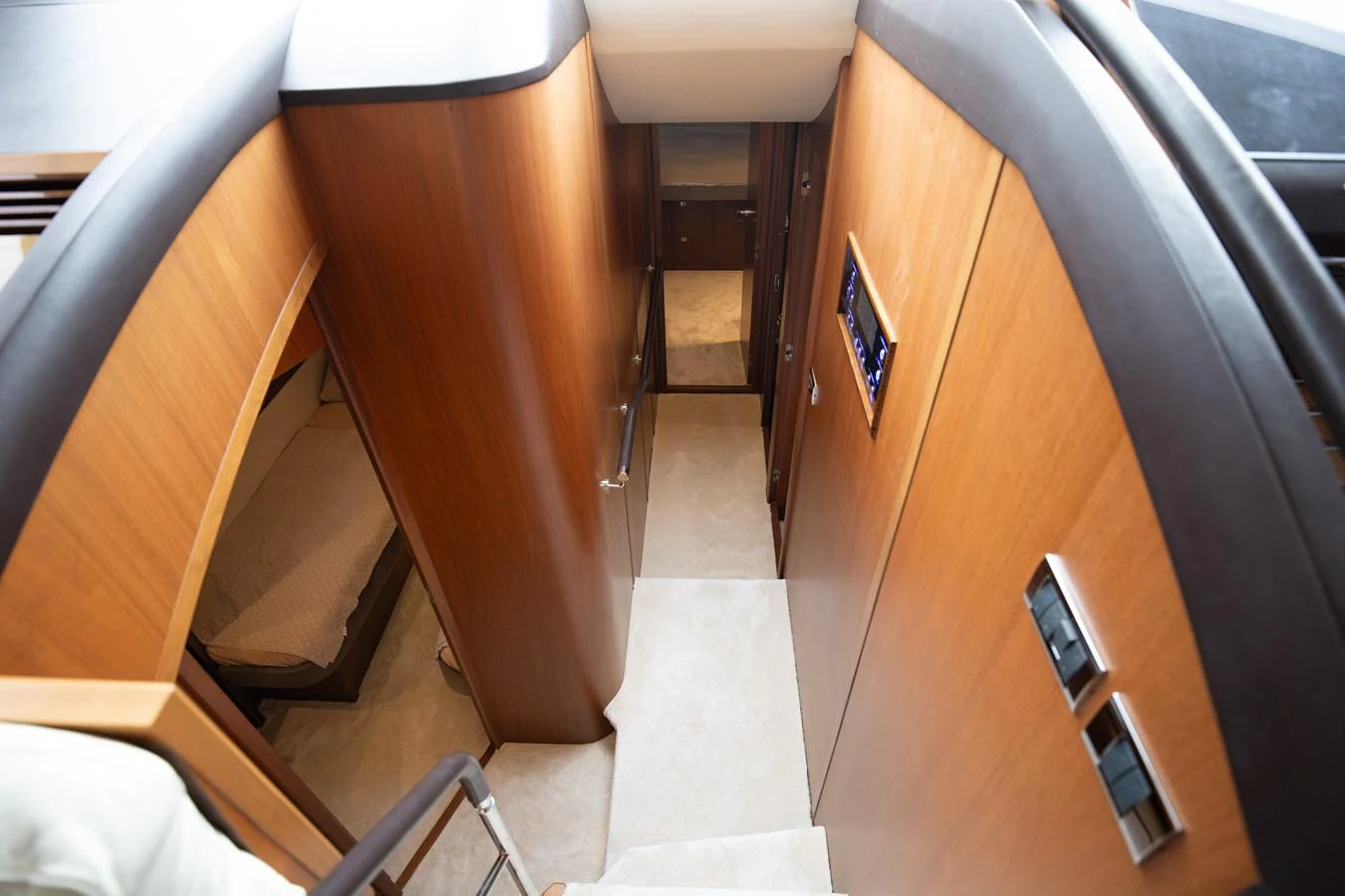 A view of the yacht's interior hallway with wooden paneling and a staircase leading down. aboard LAVIMAR II Yacht for Sale