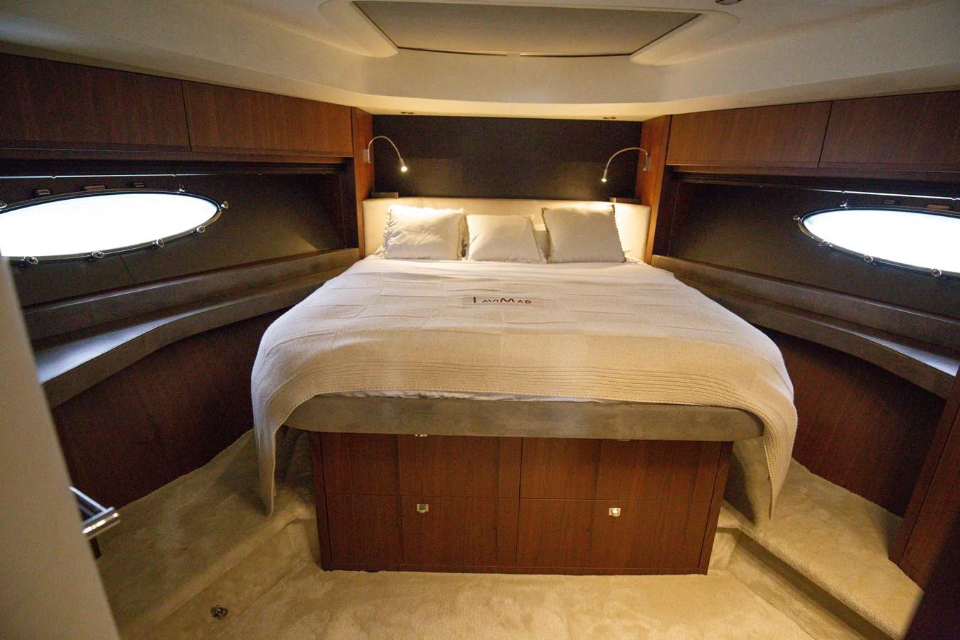 The master stateroom features a luxurious bed with elegant wood paneling and ambient lighting. aboard LAVIMAR II Yacht for Sale