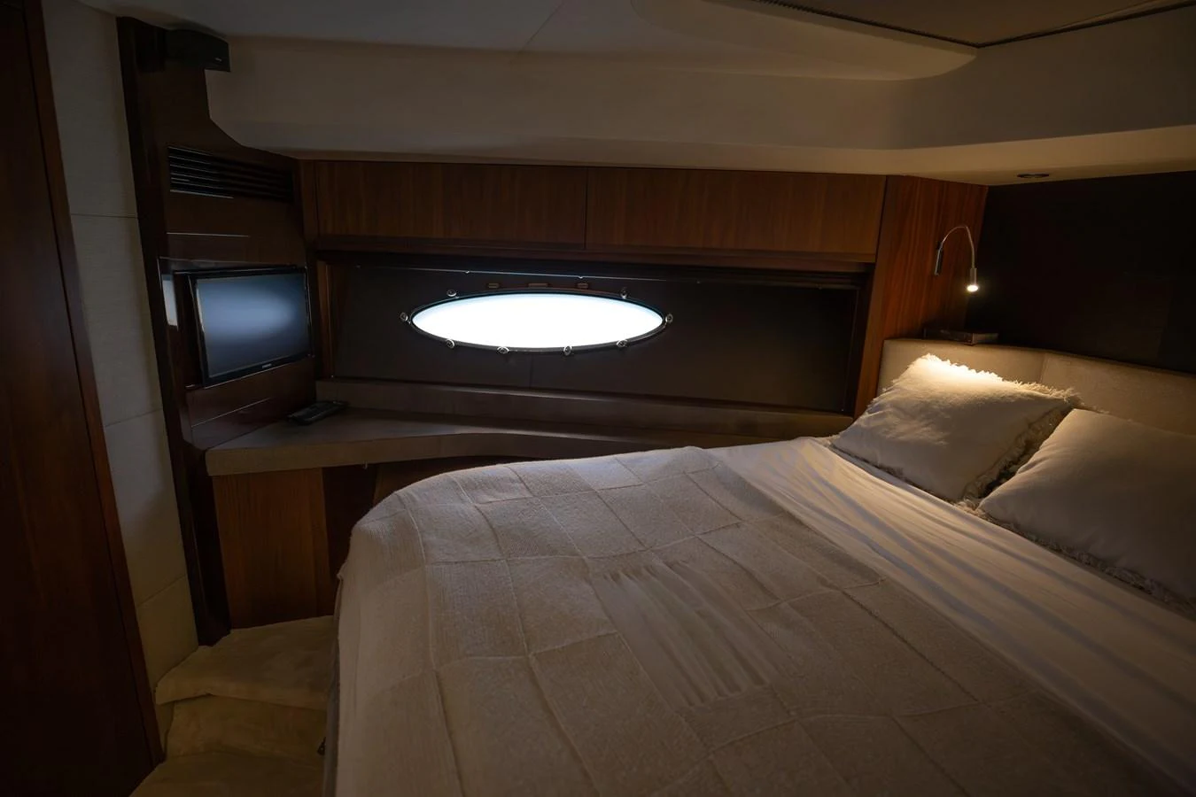 A cozy stateroom featuring a comfortable bed and a porthole window for natural light. aboard LAVIMAR II Yacht for Sale