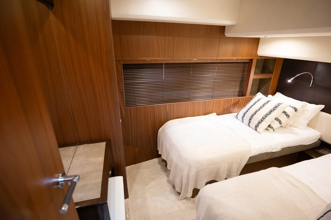 The guest stateroom features twin beds with elegant bedding and warm wood paneling. aboard LAVIMAR II Yacht for Sale