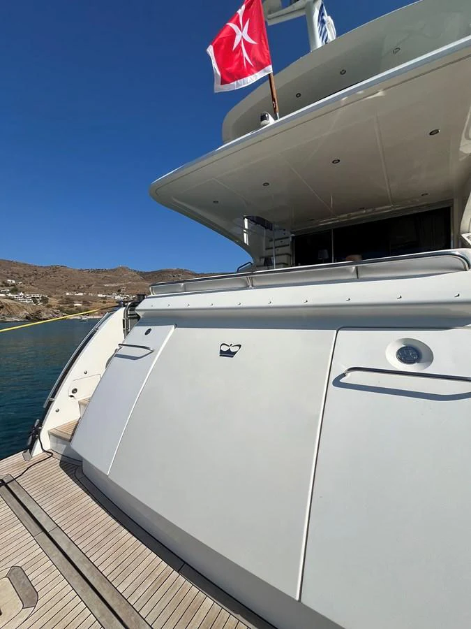 The yacht's stern showcases a sleek design with a flag flying above. aboard LAVIMAR II Yacht for Sale