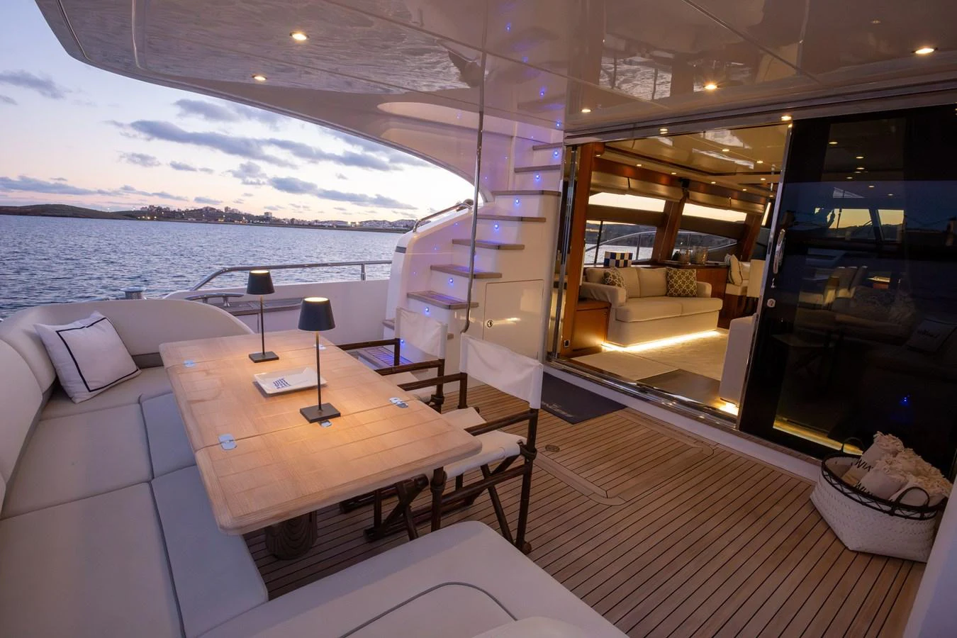 The aft deck offers a luxurious outdoor dining area with a seamless transition to the interior lounge. aboard LAVIMAR II Yacht for Sale
