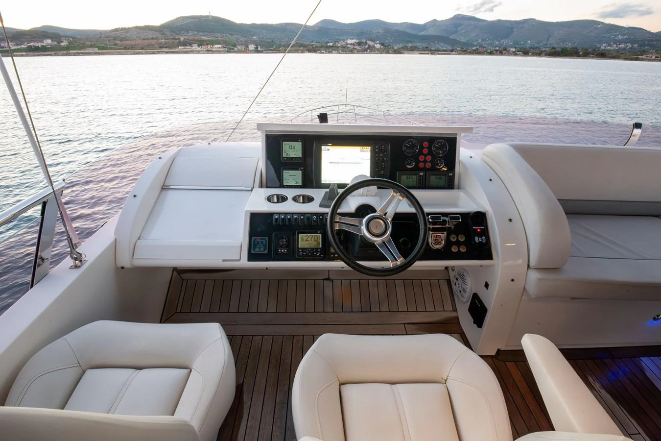 The helm station features modern controls and comfortable seating with a scenic view. aboard LAVIMAR II Yacht for Sale