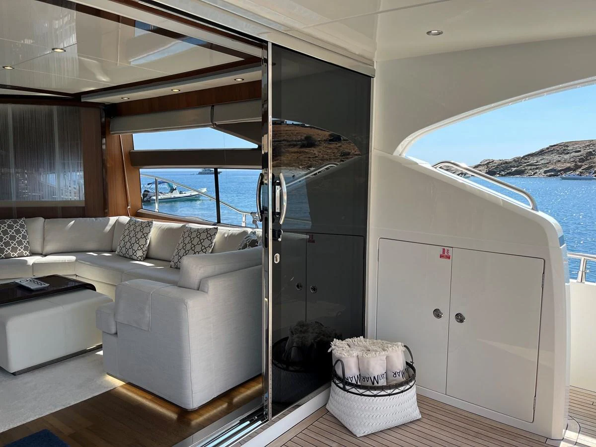 The salon offers a luxurious and comfortable seating area with a view of the water through large windows. aboard LAVIMAR II Yacht for Sale