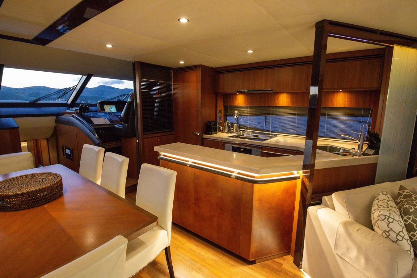 The yacht's galley features modern appliances and a sleek design, seamlessly integrated with the dining area. aboard LAVIMAR II Yacht for Sale