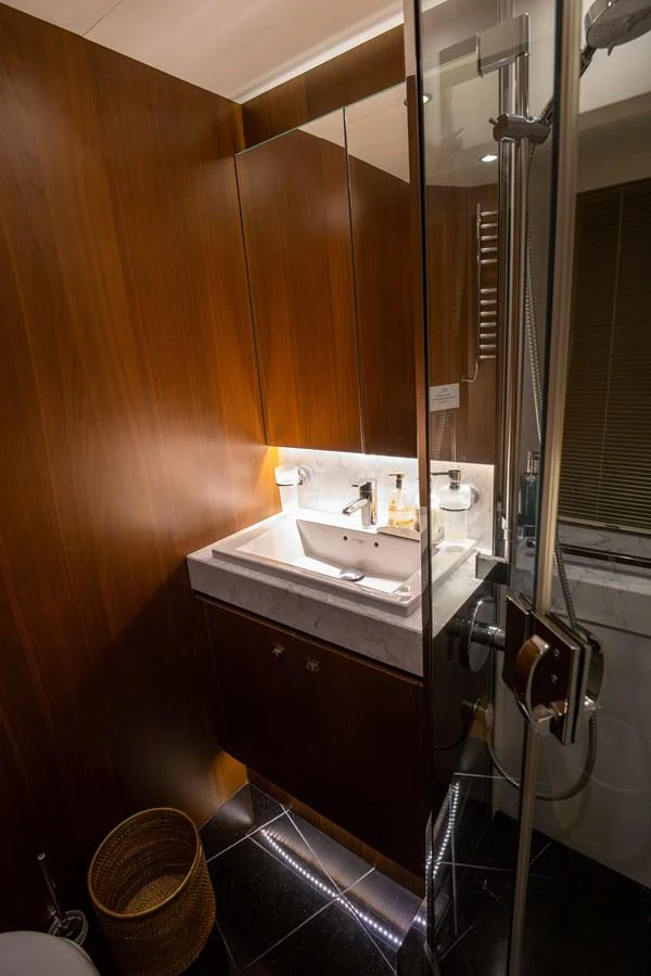 The yacht's bathroom features elegant wood paneling and modern fixtures. aboard LAVIMAR II Yacht for Sale