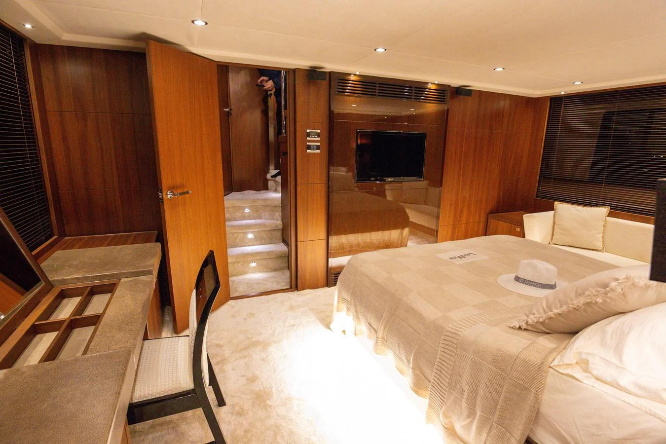 The master stateroom features luxurious wood paneling and a comfortable bed with elegant bedding. aboard LAVIMAR II Yacht for Sale