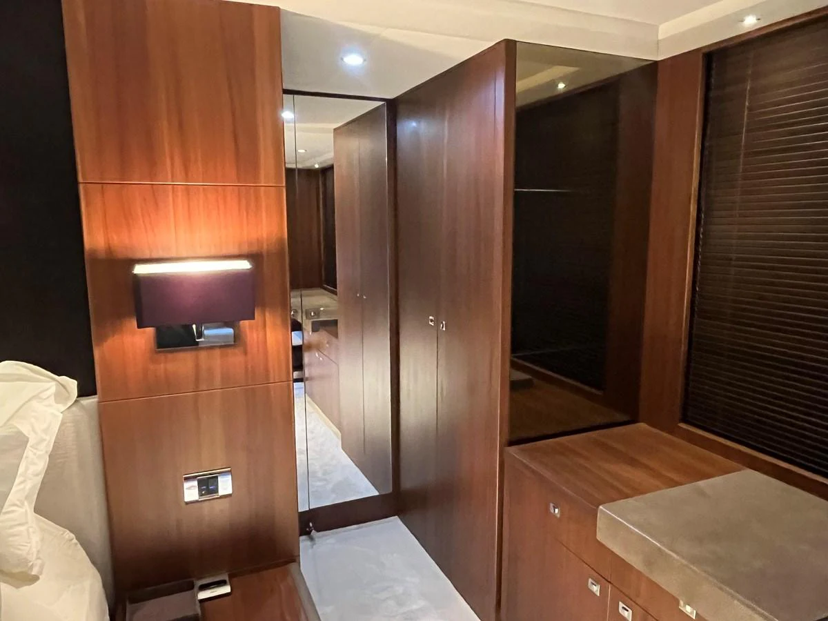 The image showcases a luxurious wooden interior with modern lighting and ample storage space. aboard LAVIMAR II Yacht for Sale