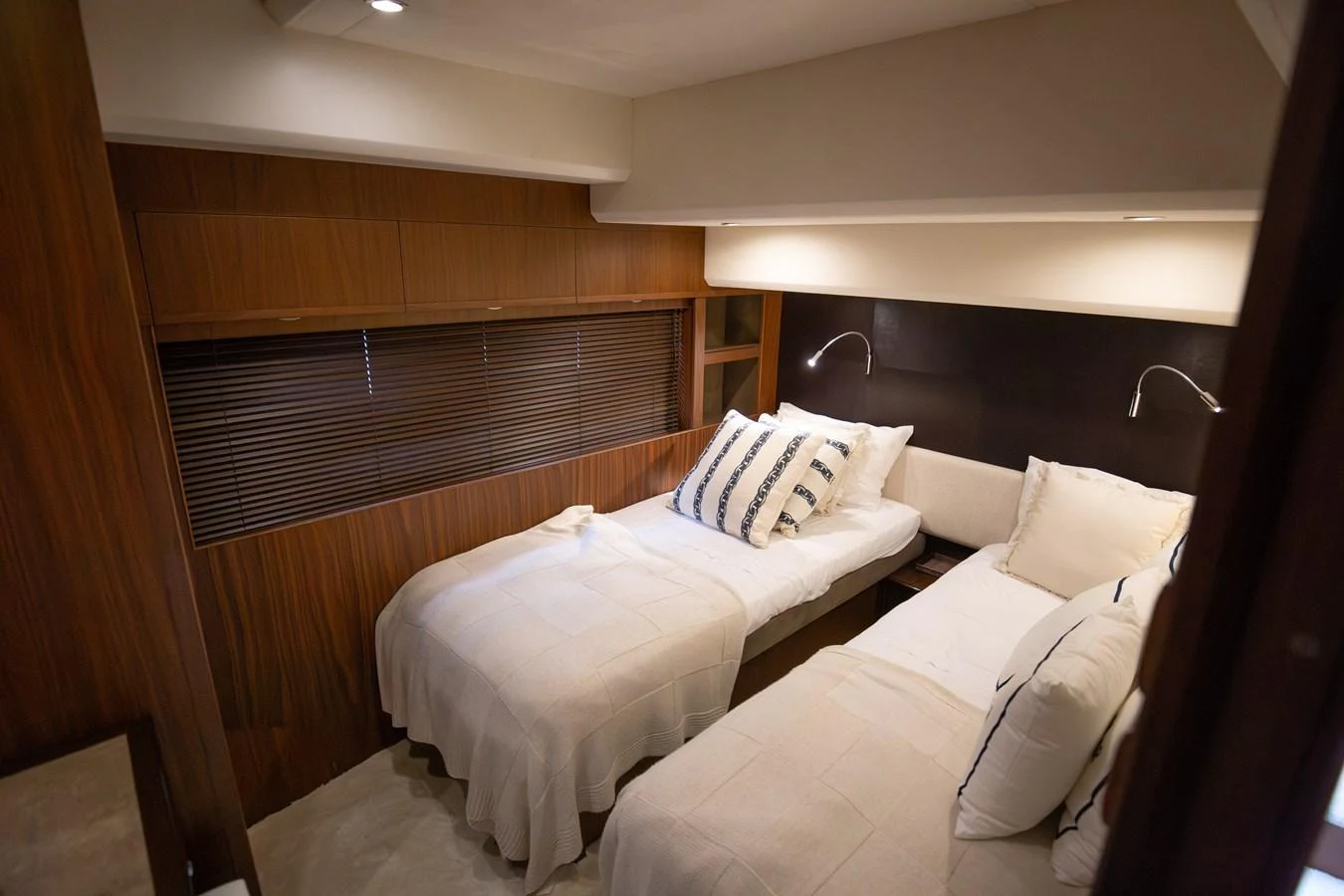 The guest stateroom features twin beds with elegant bedding and warm wood accents. aboard LAVIMAR II Yacht for Sale