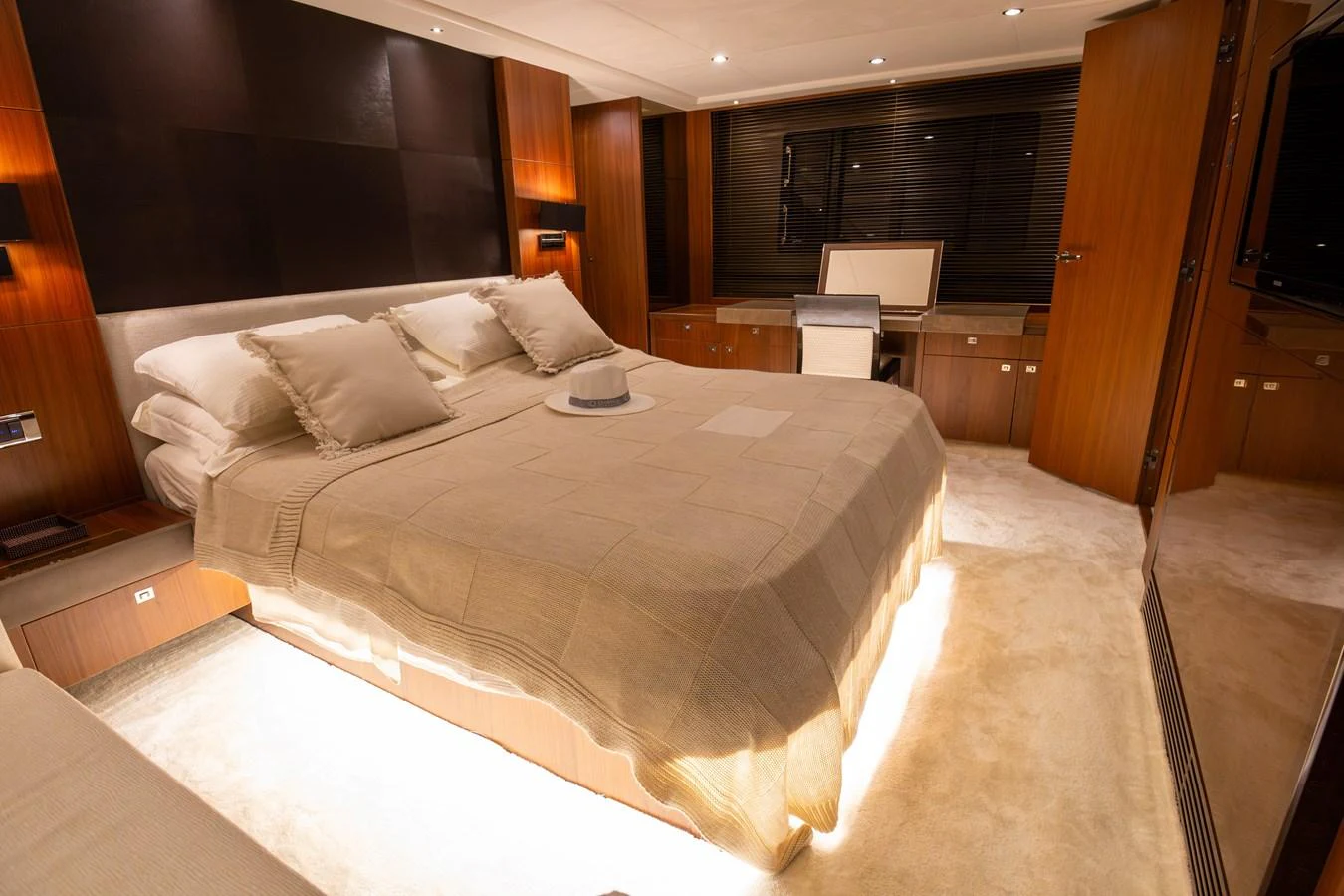 The master stateroom features a luxurious bed with elegant bedding and warm wood accents. aboard LAVIMAR II Yacht for Sale