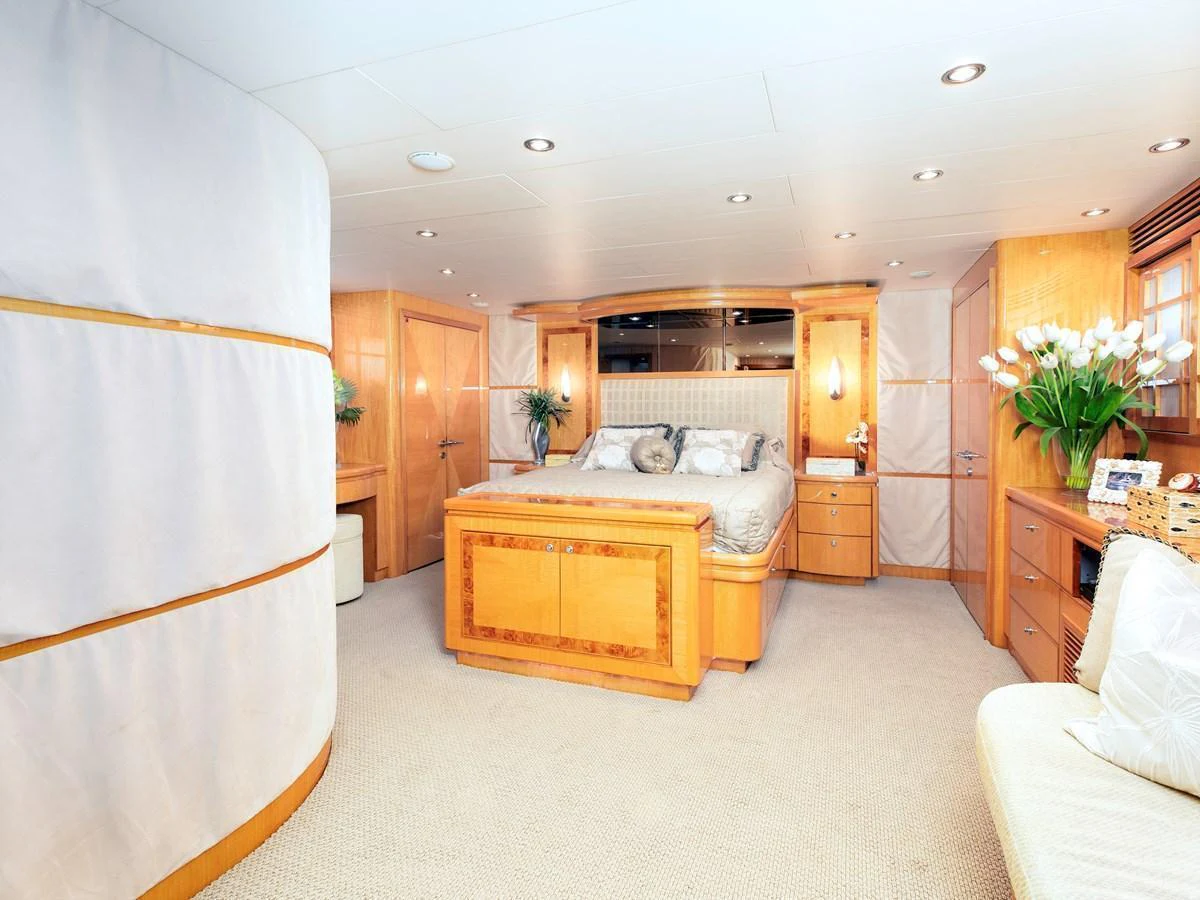 The master stateroom features a spacious layout with luxurious bedding and elegant wood finishes. aboard MELODIOUS LL Yacht for Sale