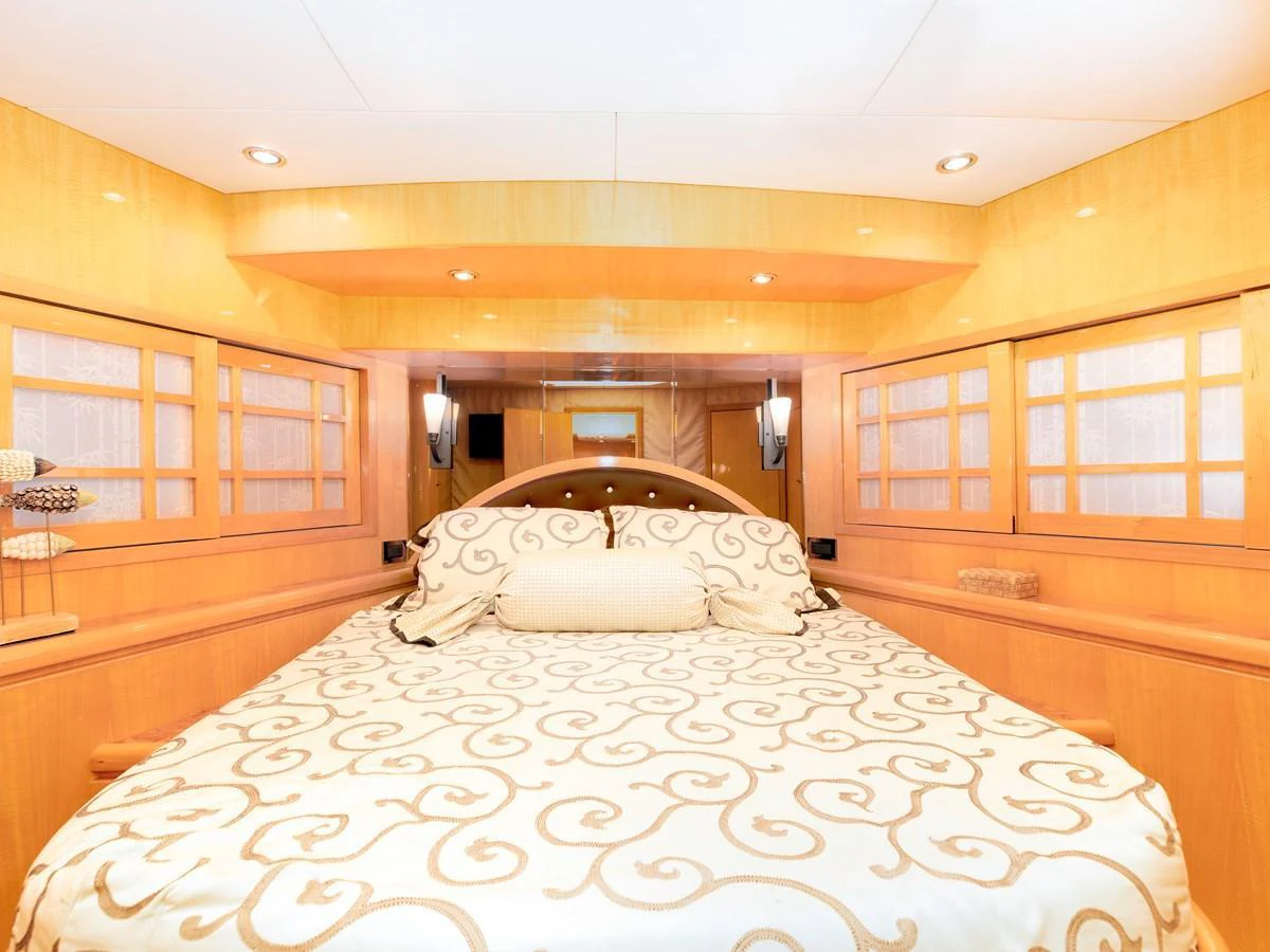 The stateroom features a luxurious bed with elegant bedding and ample natural light. aboard MELODIOUS LL Yacht for Sale