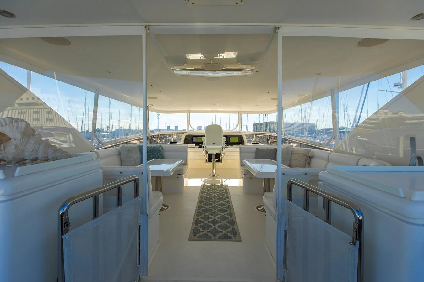 The helm area features a spacious and well-lit seating arrangement with a central captain's chair and panoramic views. aboard MELODIOUS LL Yacht for Sale