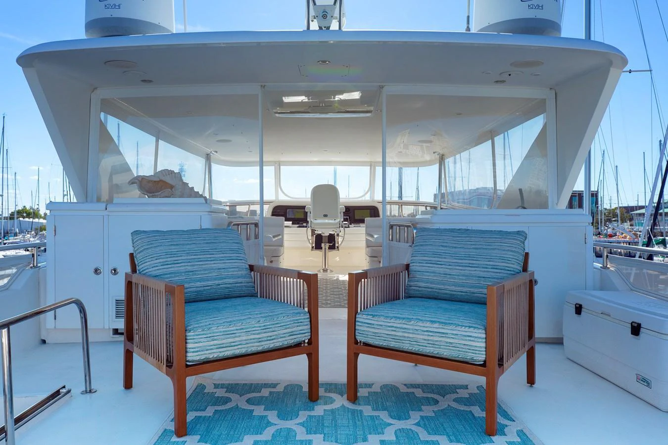 The flybridge offers a comfortable seating area with two cushioned chairs and a view of the helm station. aboard MELODIOUS LL Yacht for Sale