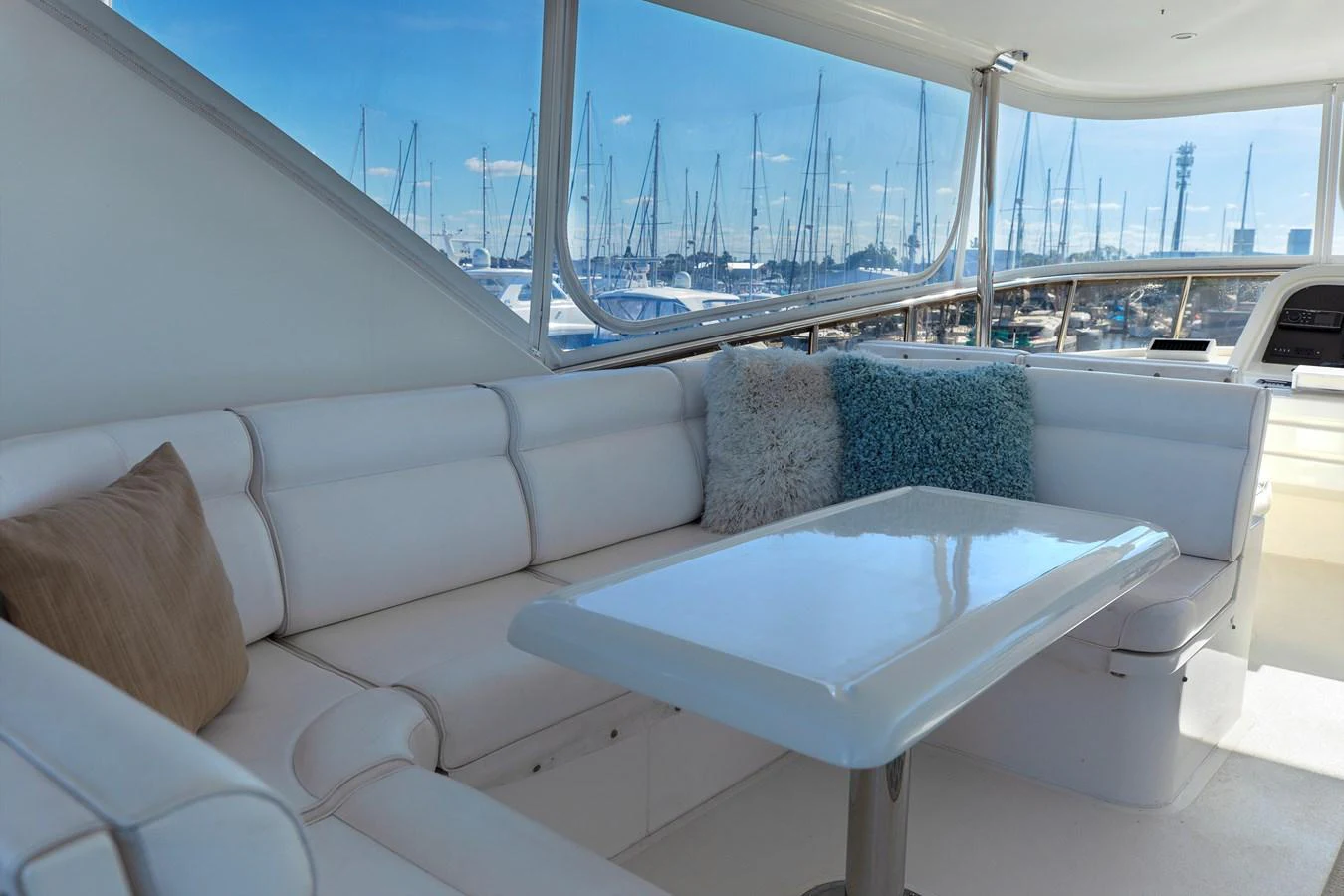 The yacht's salon features a plush seating area with a sleek table, offering a comfortable and stylish space to relax. aboard MELODIOUS LL Yacht for Sale