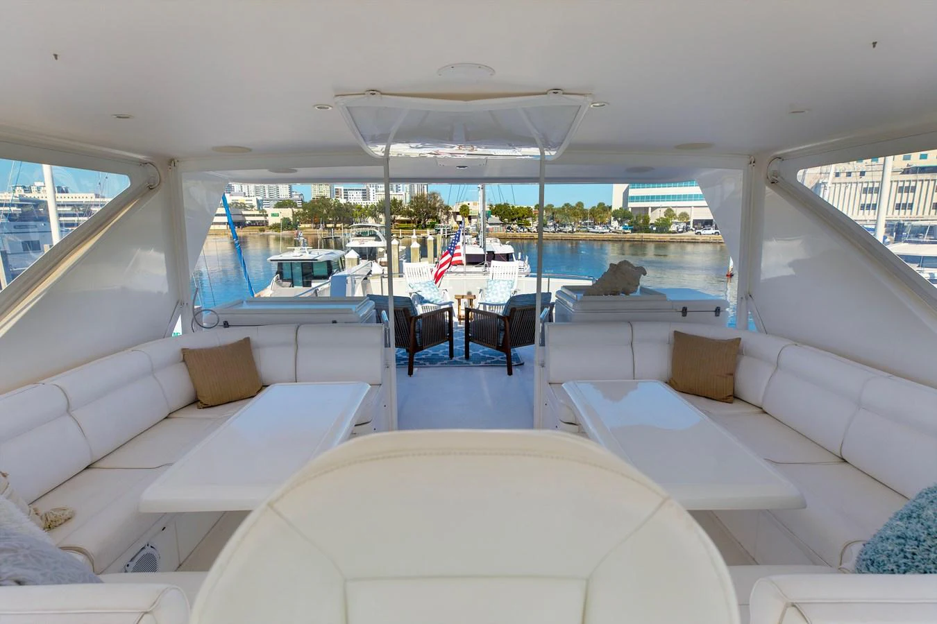 The salon offers a spacious and inviting area with plush seating and a view of the marina. aboard MELODIOUS LL Yacht for Sale