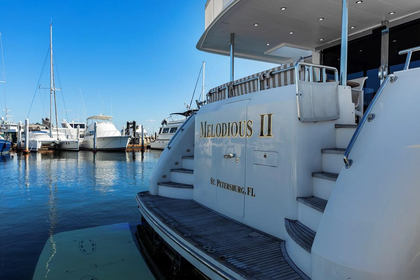 The aft deck of the yacht features elegant stairs and a spacious platform, perfect for easy access to the water. aboard MELODIOUS LL Yacht for Sale