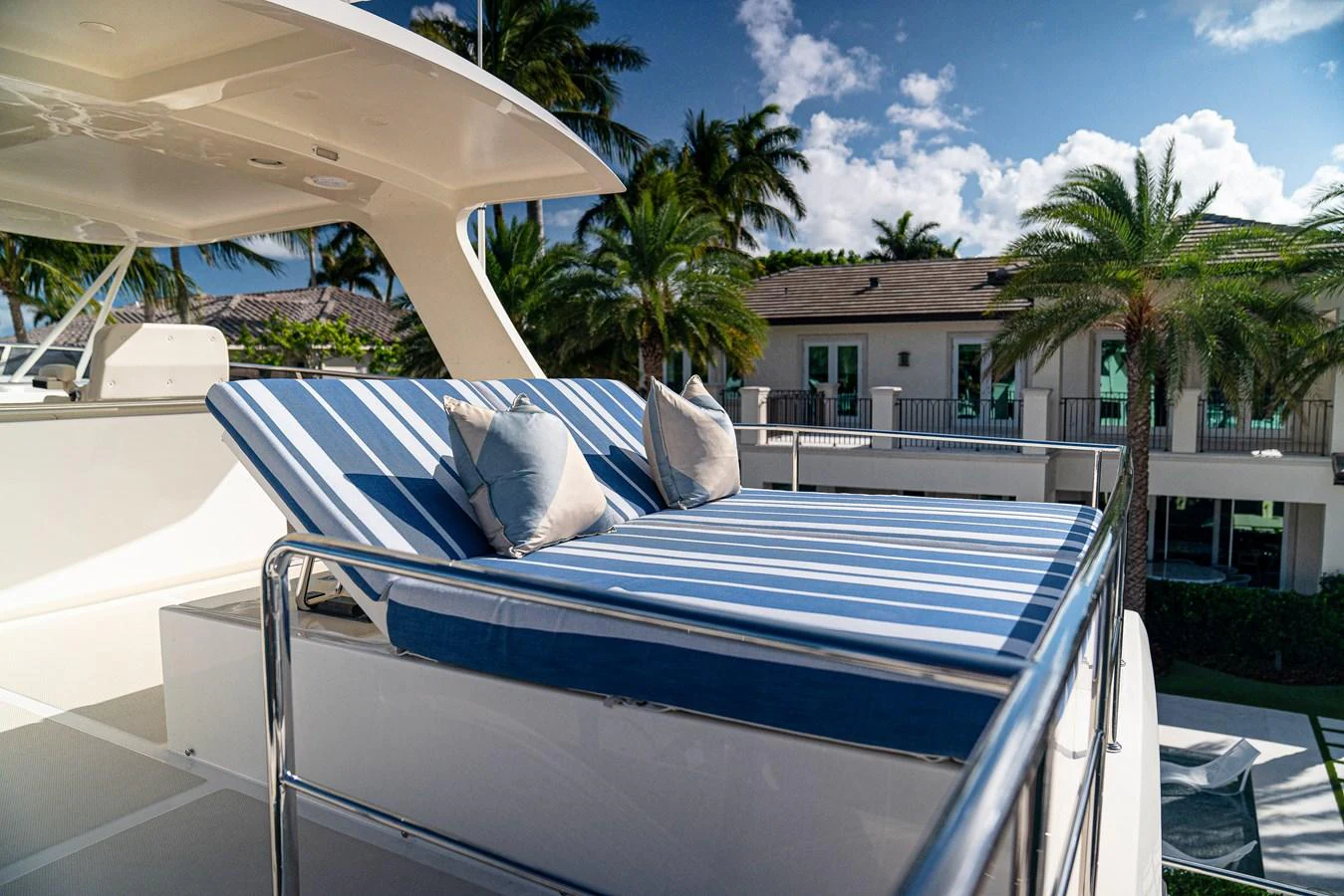 a large white lounge chair on a deck with a pool and trees aboard TOP TIMES Yacht for Sale