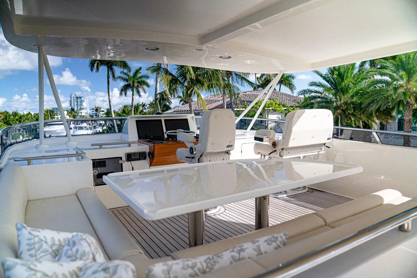 a large white lounge chair on a deck with a large white table and chairs and palm trees aboard TOP TIMES Yacht for Sale