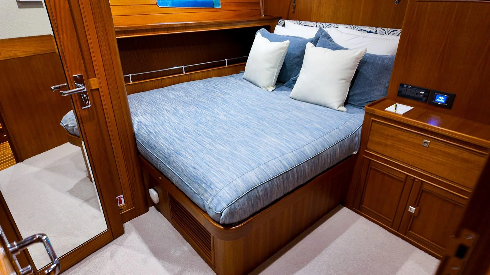 a bed with a blue and white comforter and a wooden dresser aboard TOP TIMES Yacht for Sale