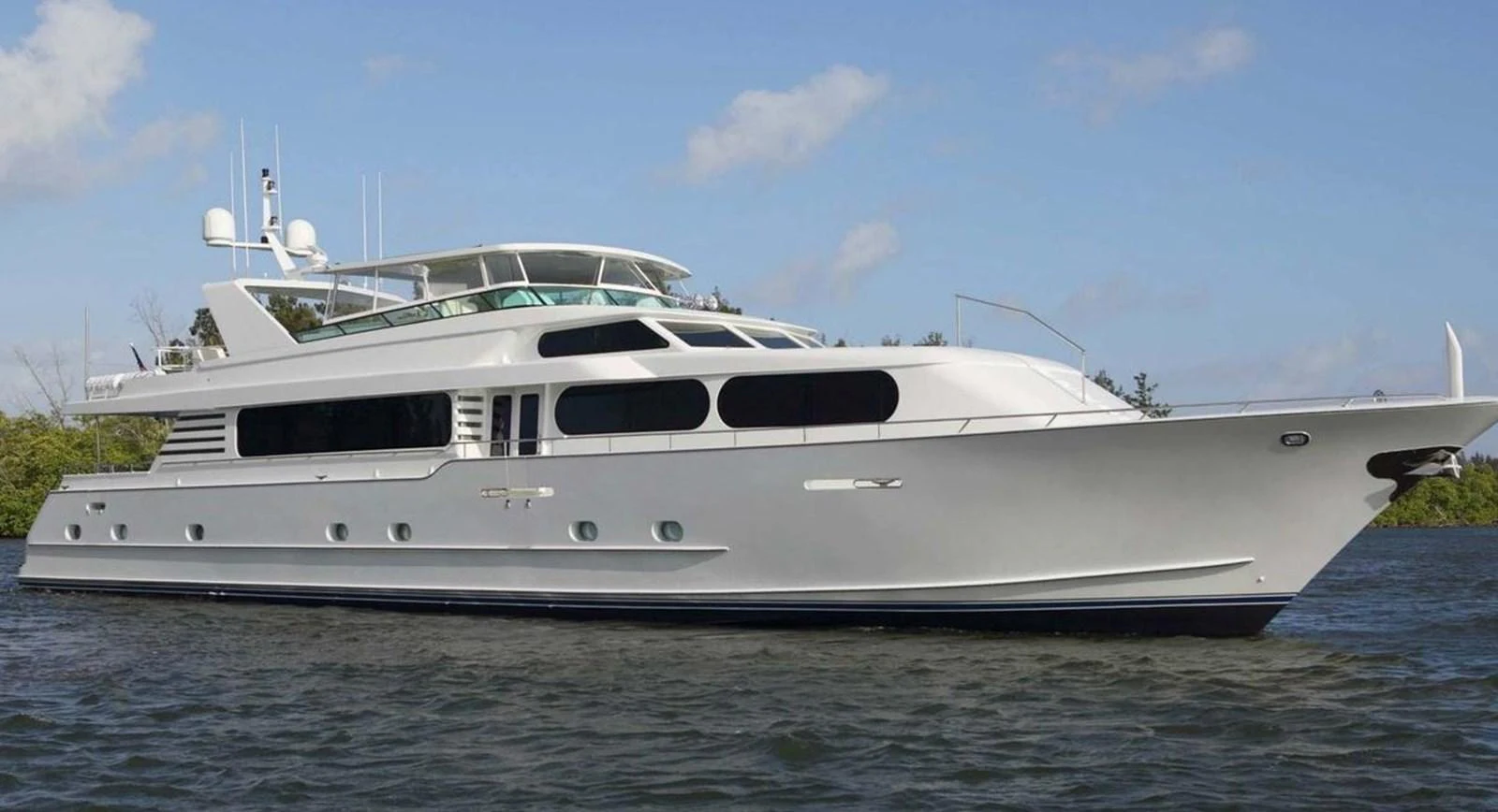A sleek and elegant yacht cruising on calm waters under a clear blue sky. aboard IRON LADY Yacht for Sale