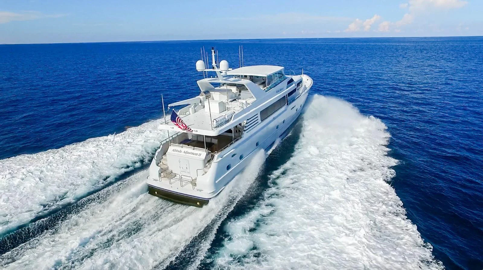 A luxurious yacht speeds across the open sea, leaving a trail of white foam in its wake. aboard IRON LADY Yacht for Sale
