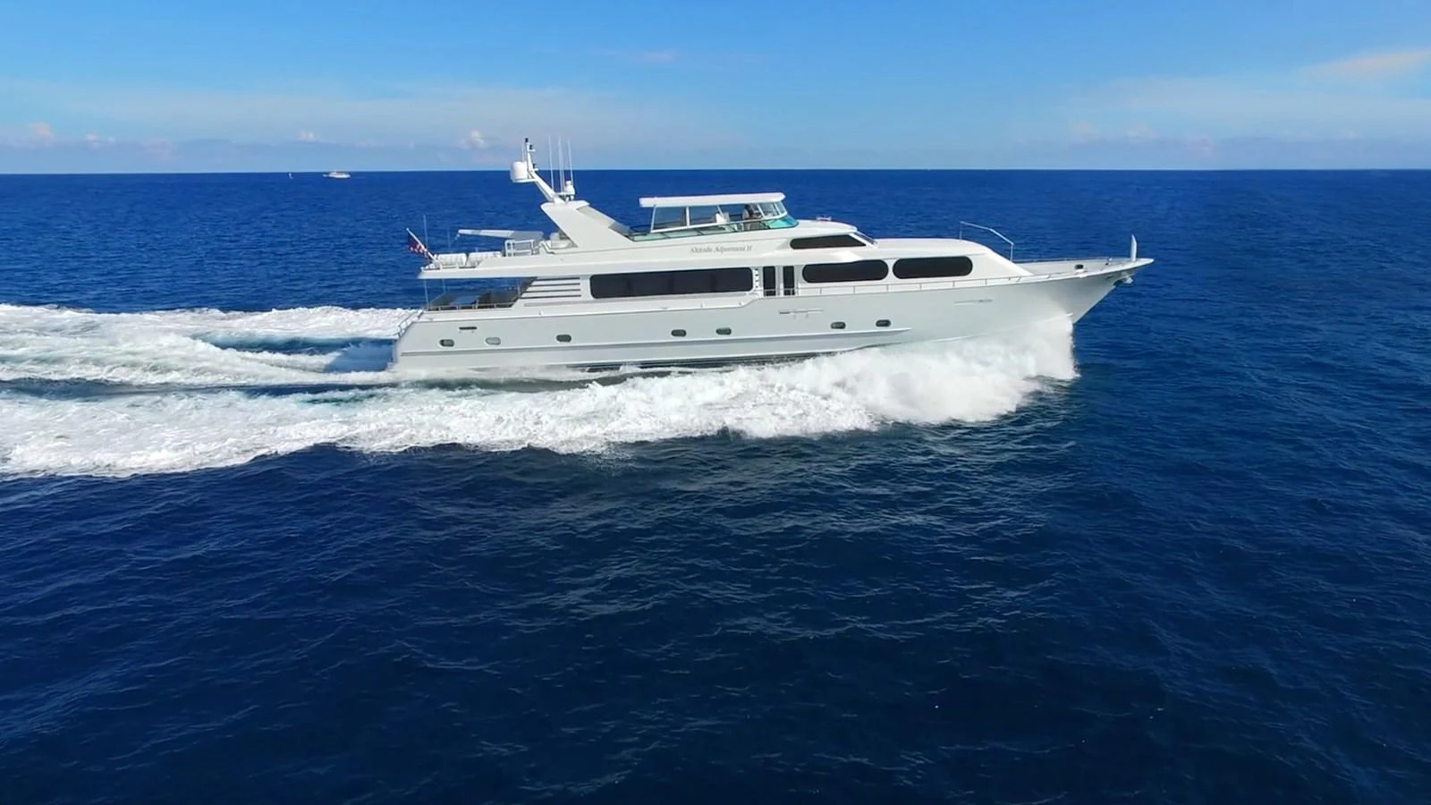 A sleek yacht cruises swiftly through the open sea under a clear blue sky. aboard IRON LADY Yacht for Sale