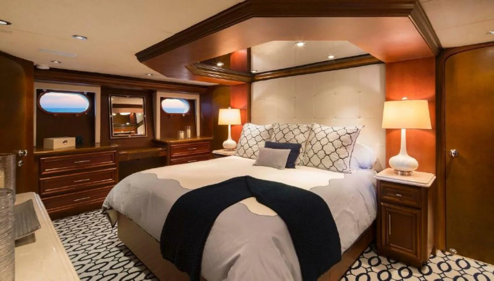 The master stateroom features a luxurious bed with elegant bedding and warm lighting. aboard IRON LADY Yacht for Sale
