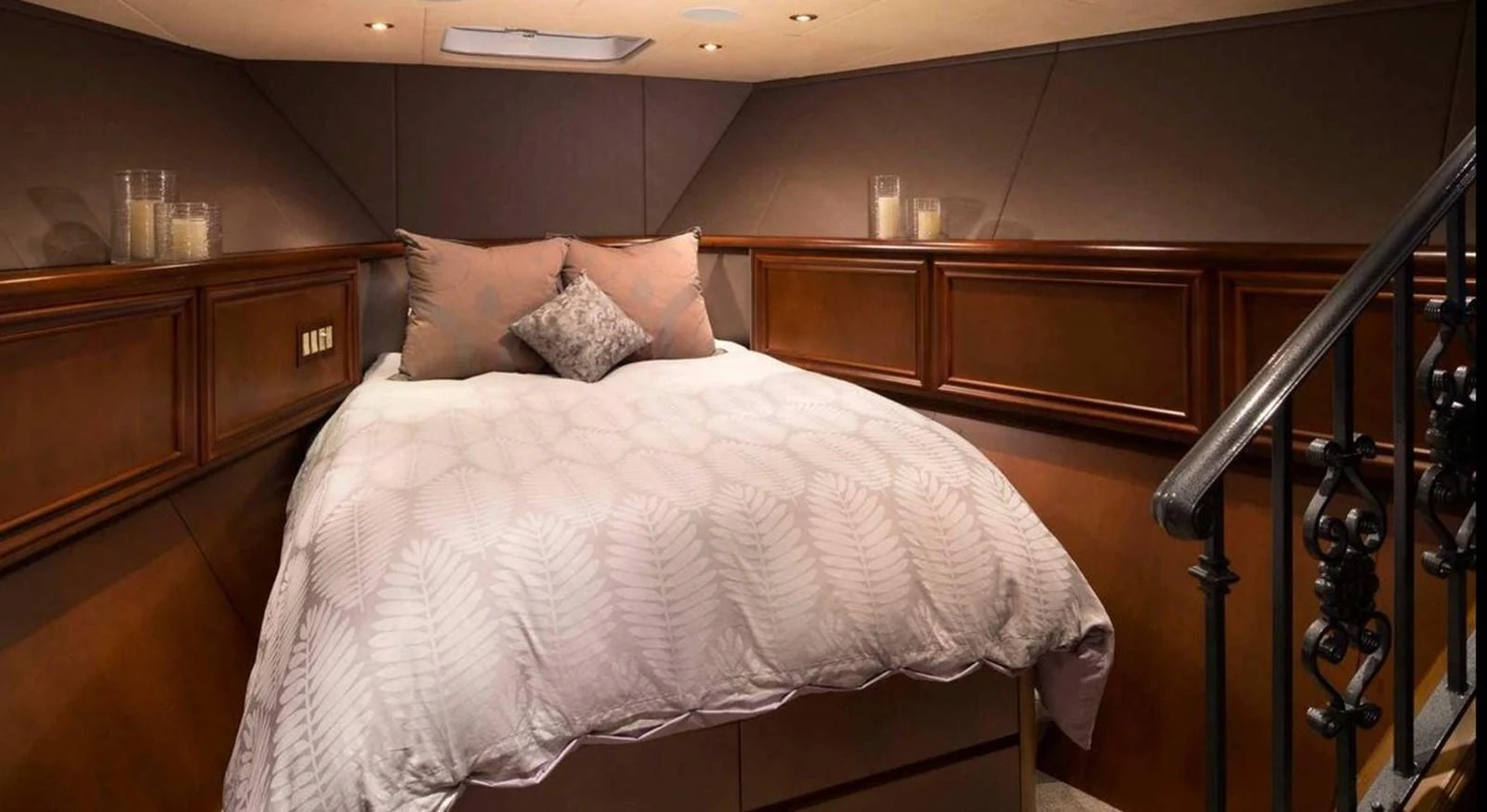 The cozy stateroom features a comfortable bed with elegant bedding and warm lighting. aboard IRON LADY Yacht for Sale