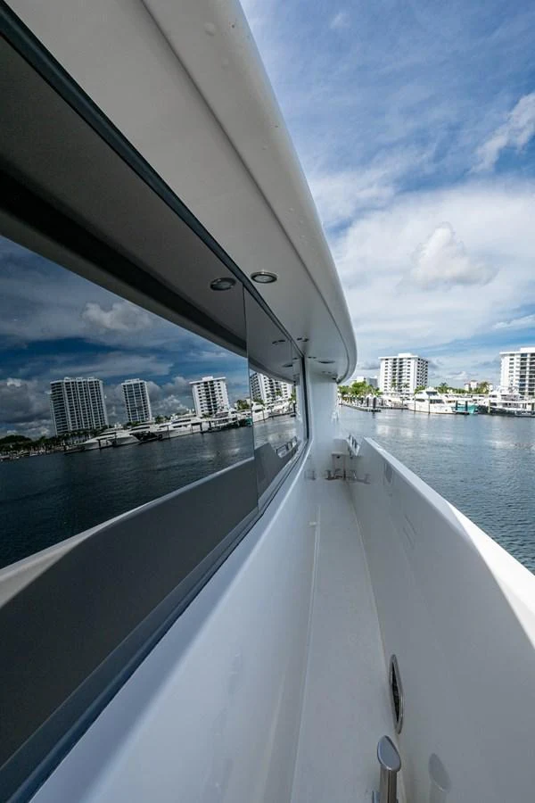 A sleek exterior walkway with a view of the marina and cityscape. aboard LILA CUY Yacht for Sale