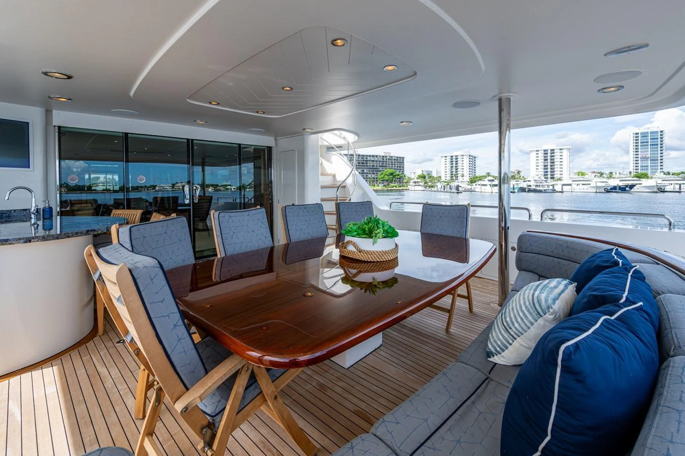 The aft deck features a spacious dining area with a polished wooden table and comfortable seating, perfect for alfresco dining. aboard LILA CUY Yacht for Sale