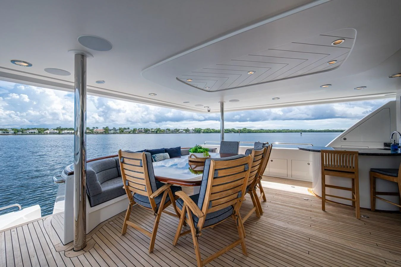 The aft deck features a spacious seating area with a dining table and bar, perfect for alfresco dining and relaxation. aboard LILA CUY Yacht for Sale