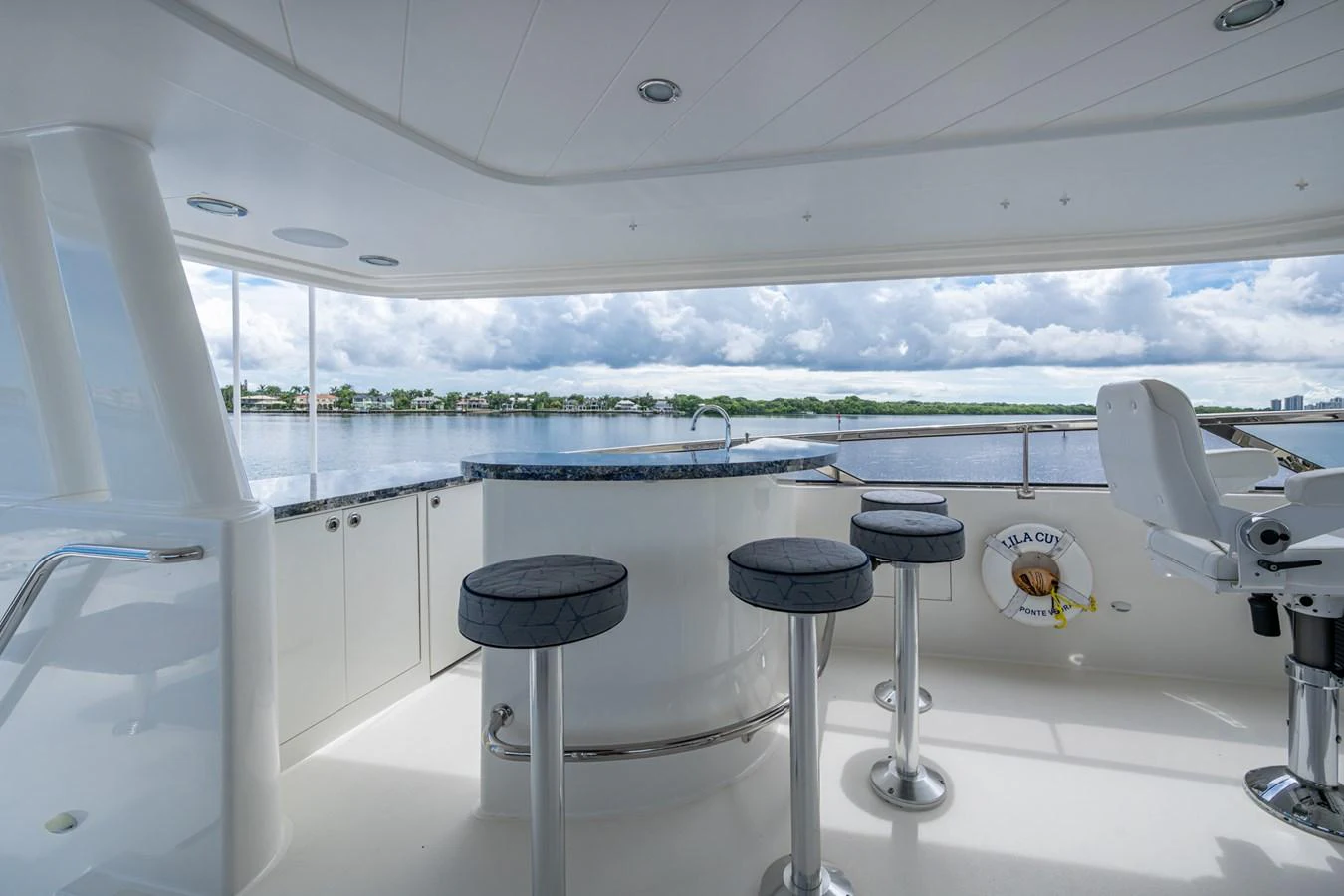 The flybridge offers a serene space with bar seating and panoramic views of the water. aboard LILA CUY Yacht for Sale