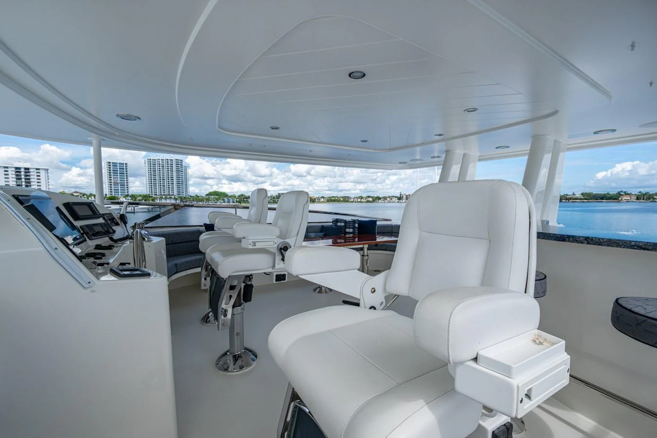 The helm station features luxurious white leather chairs and advanced navigation equipment, offering a commanding view of the water. aboard LILA CUY Yacht for Sale
