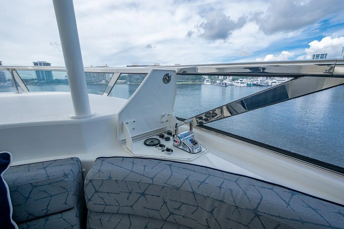 A close-up view of a yacht's control panel with a scenic waterfront backdrop. aboard LILA CUY Yacht for Sale