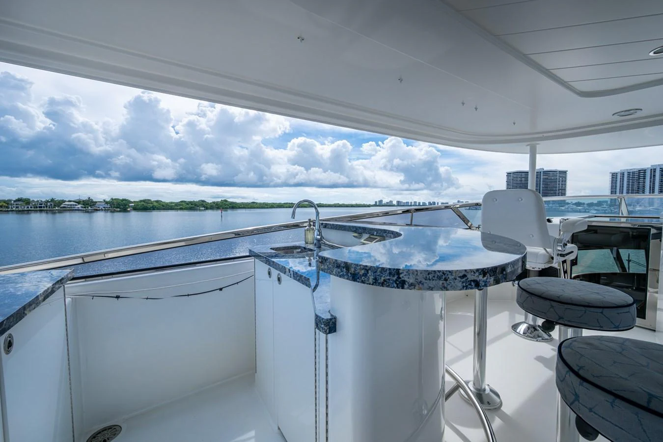 The flybridge features a sleek bar area with a stunning view of the water and skyline. aboard LILA CUY Yacht for Sale