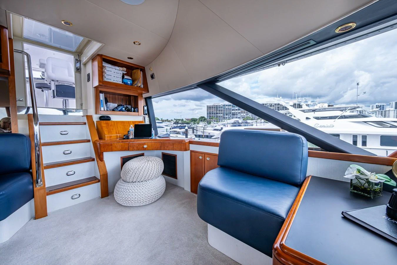 The yacht's salon features comfortable seating with a view of the marina through large windows. aboard LILA CUY Yacht for Sale