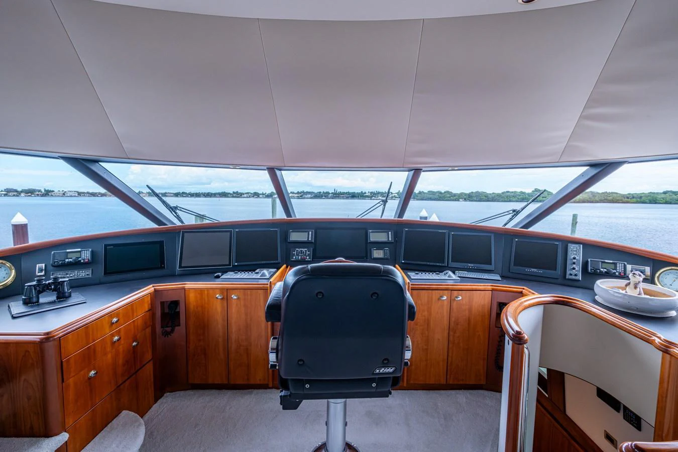 The helm station offers a commanding view with state-of-the-art navigation equipment and luxurious wood finishes. aboard LILA CUY Yacht for Sale