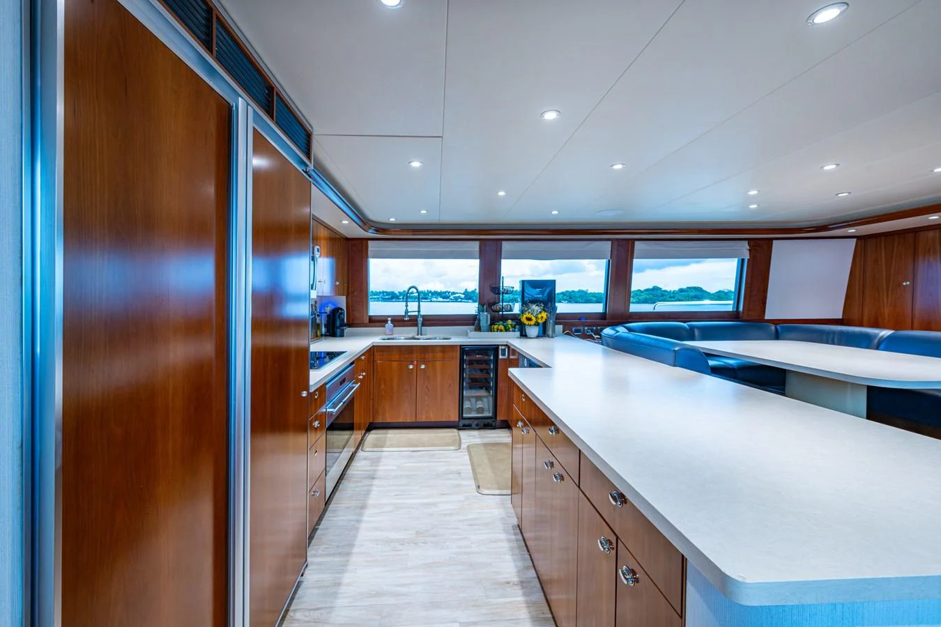 The yacht's galley features sleek wooden cabinetry, modern appliances, and ample counter space with a view of the sea. aboard LILA CUY Yacht for Sale