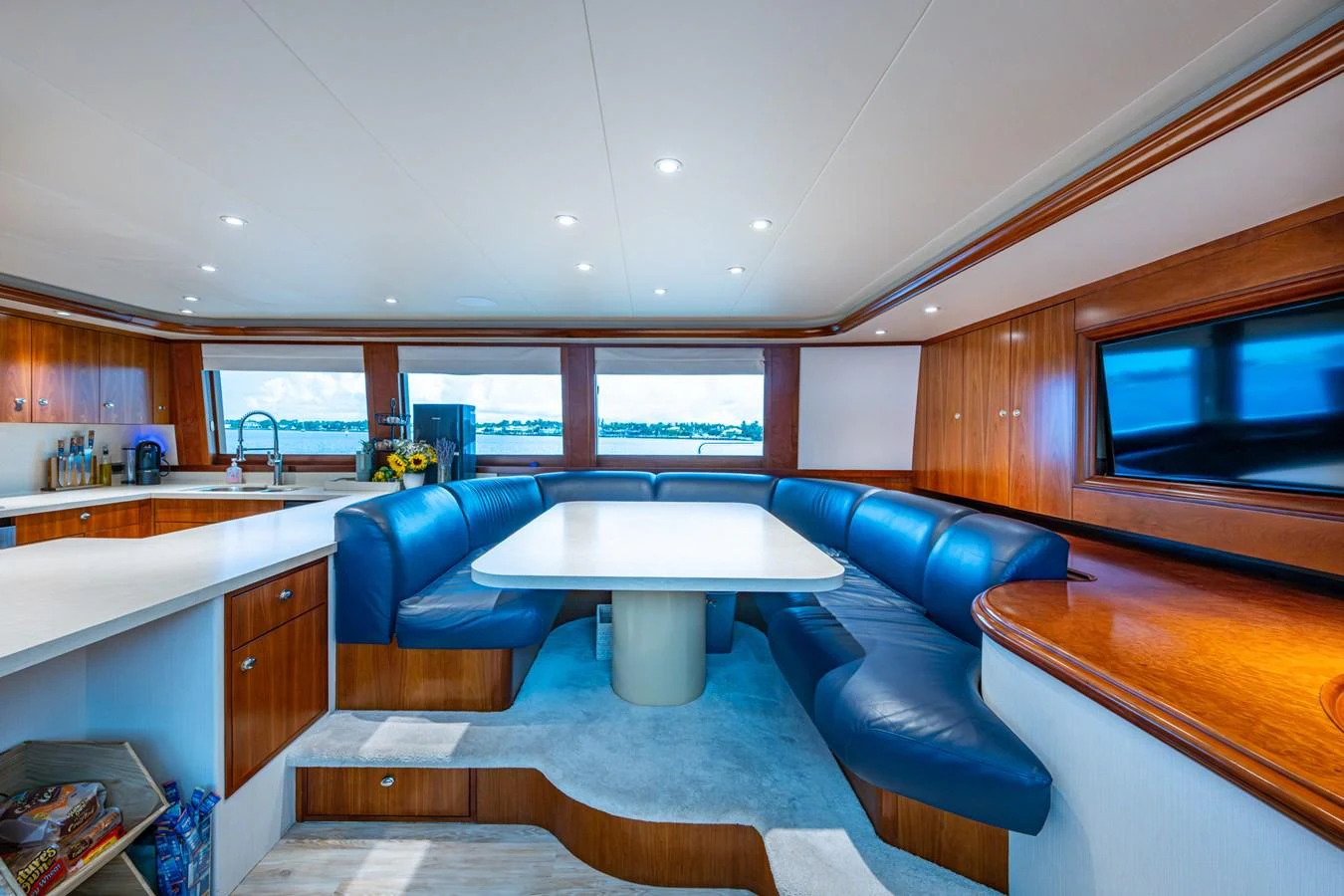 The salon features a spacious seating area with a large table and panoramic windows offering stunning views. aboard LILA CUY Yacht for Sale
