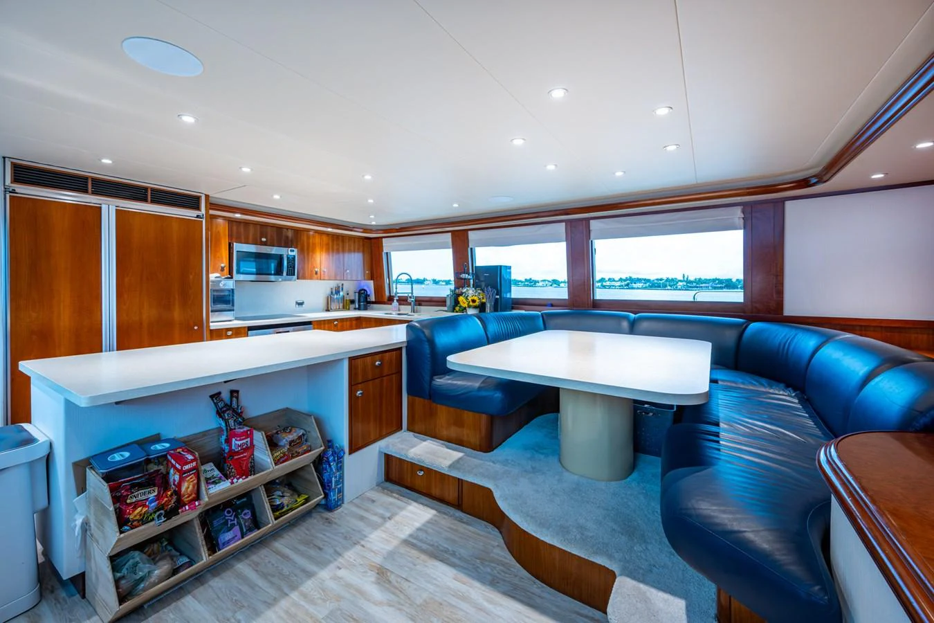The yacht's galley features a spacious dining area with a large table and comfortable seating, complemented by modern kitchen amenities. aboard LILA CUY Yacht for Sale