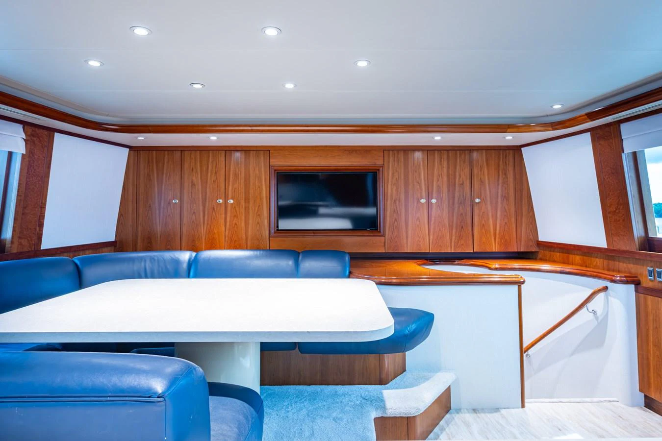 The yacht's salon features a spacious seating area with a large table and a flat-screen TV. aboard LILA CUY Yacht for Sale