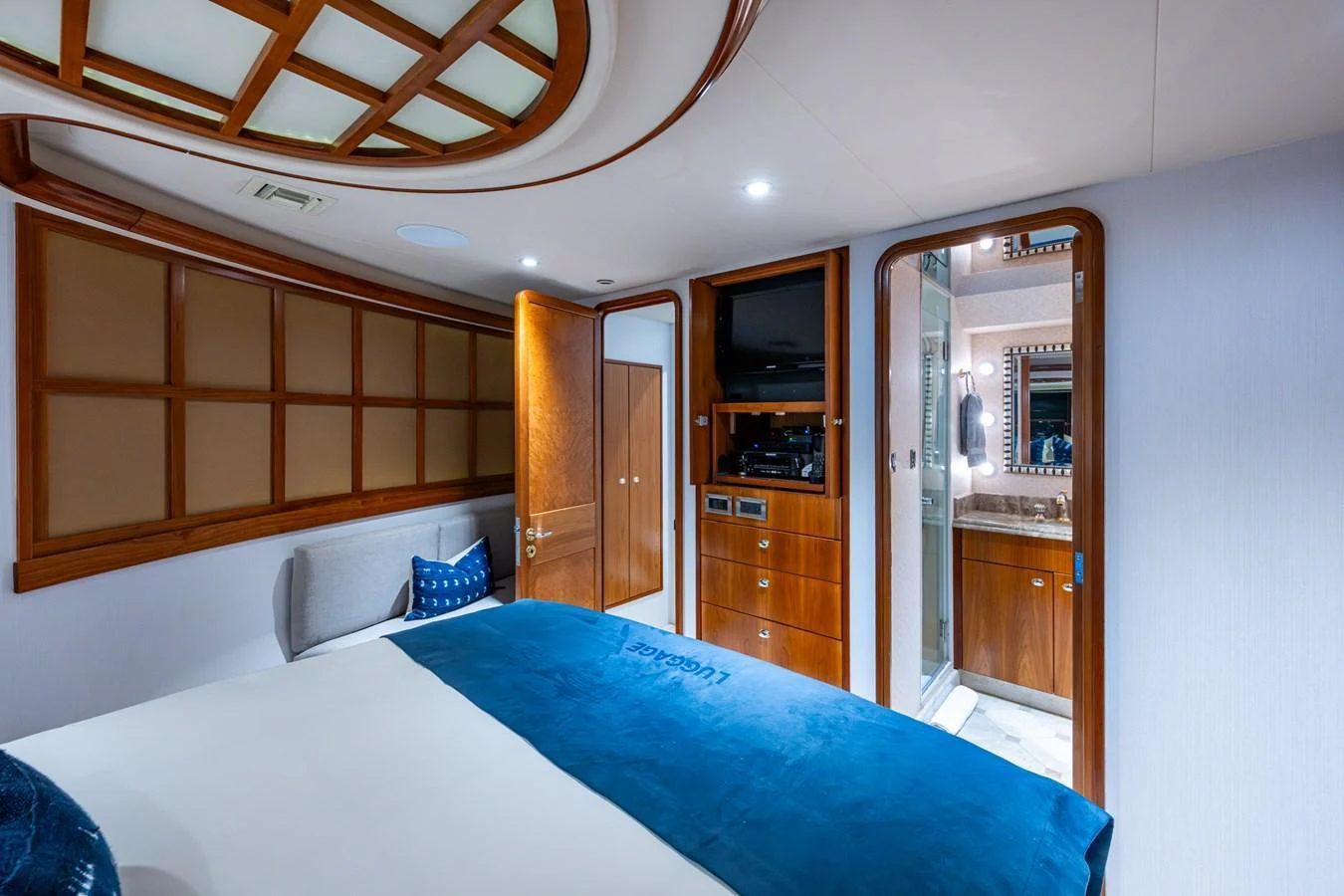 A luxurious stateroom featuring a comfortable bed, wooden accents, and an en-suite bathroom. aboard LILA CUY Yacht for Sale