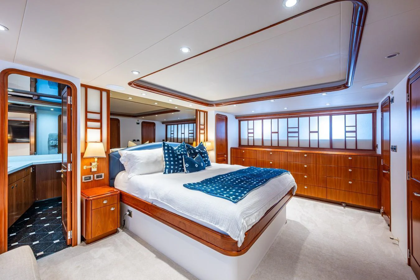 The master stateroom features a spacious bed with elegant wooden cabinetry and modern lighting. aboard LILA CUY Yacht for Sale