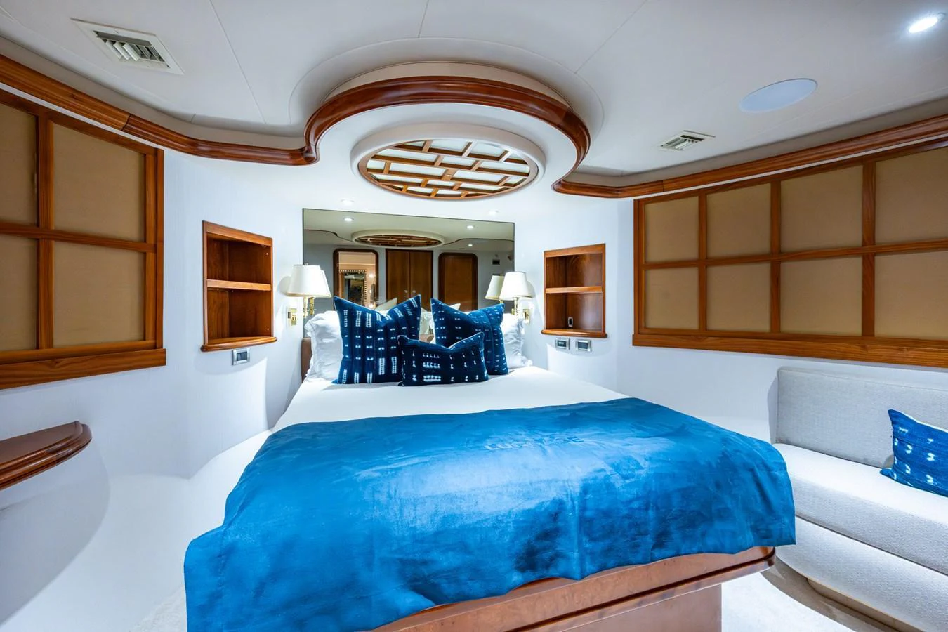 The stateroom features a luxurious bed with blue accents and elegant wooden details. aboard LILA CUY Yacht for Sale
